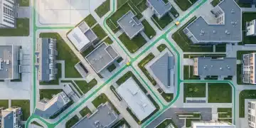 Aerial view of a city district with green pathways connecting buildings, symbolizing public assistance infrastructure.
