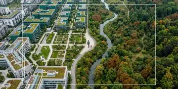 High aerial drone view of a vibrant green urban area blending into a natural park, with individuals in both settings, symbolizing the global shift to remote work and evolving work-life integration.