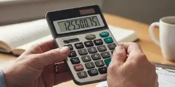 Hands calculating Social Security benefits with a calculator and card.